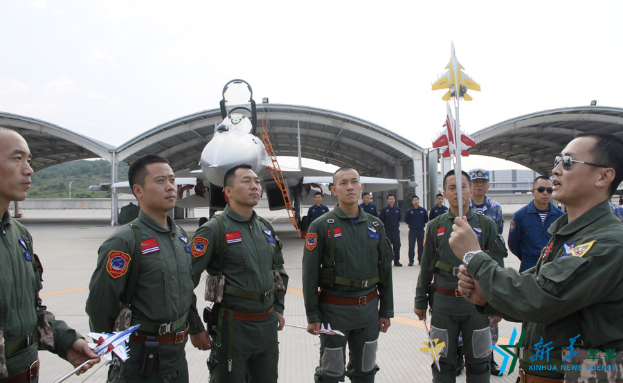 &uarr;艦載航空兵某部司令員戴明盟向飛行員演示空中飛行注意事項。