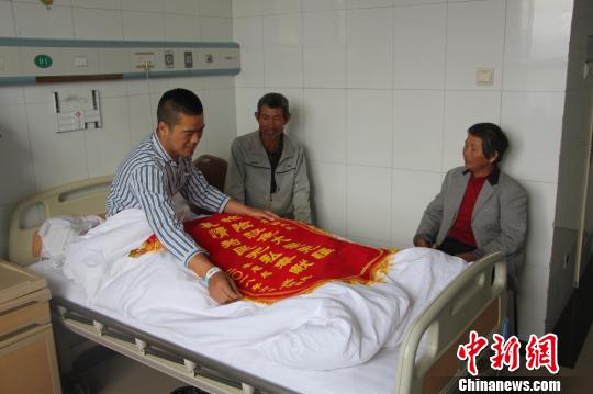 被救的李忠起、張總鳳夫婦看望受傷后的李運(yùn)飛?！⊥粲?攝