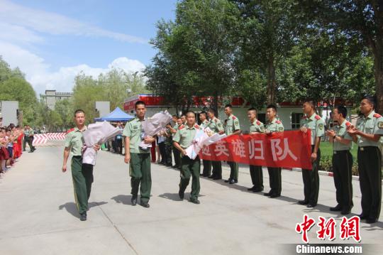 部隊(duì)官兵們迎接出院歸來的李運(yùn)飛(中)和其他消防戰(zhàn)士?！⊥粲?攝