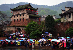 游客在鳳凰古城北門(mén)城樓下冒雨等待乘船游覽