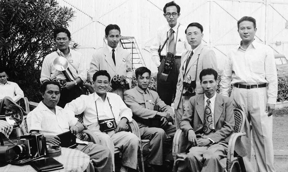 新華社記者錢嗣杰（站立者右二）在采訪會議開幕式后和外國記者在會場外休息。