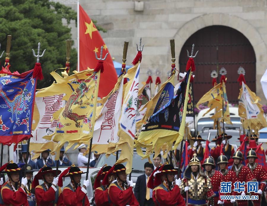 7月3日，韓國總統(tǒng)樸槿惠在青瓦臺總統(tǒng)府舉行隆重儀式，歡迎中國國家主席習(xí)近平對韓國進(jìn)行國事訪問。這是習(xí)近平的車隊(duì)在身著民族服裝的韓國禮儀隊(duì)伍引導(dǎo)下駛?cè)肭嗤吲_。新華社記者丁林?jǐn)z  