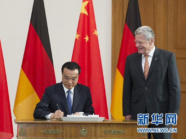 10月10日，國務(wù)院總理李克強在柏林會見德國總統(tǒng)高克。這是李克強總理在高克總統(tǒng)的陪同下在貴賓簿上簽字。 新華社記者 王曄 攝 