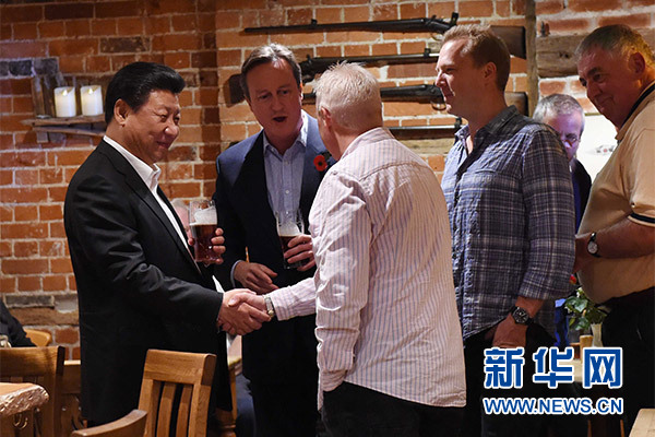 這是習(xí)近平與卡梅倫飲啤酒，并同當(dāng)?shù)孛癖娊徽劇Ｐ氯A社記者 饒愛民 攝